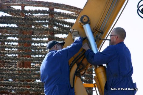 Schipper Dirk Schagen (l) en Silvan Hoep herstellen de kraan op de 'Verwachting'. Waarmee de zware mosselkorven aanboord gehesen worden en in zee worden geplaatst.